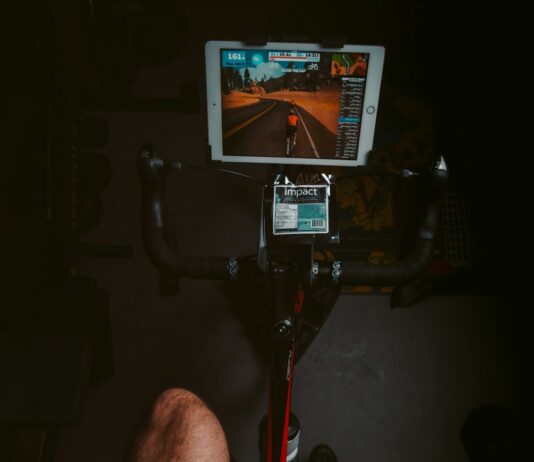 장마철 체력 유지를 위한 실내 운동 추천 person in black shorts sitting on black and red stationary bike