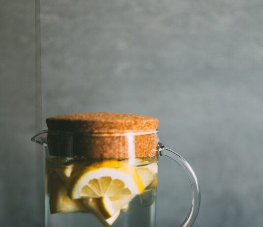 운동 성과 향상을 위한 적절한 영양: 운동 전후의 식사법 clear glass pitcher filled with sliced lemons on black and white table runner