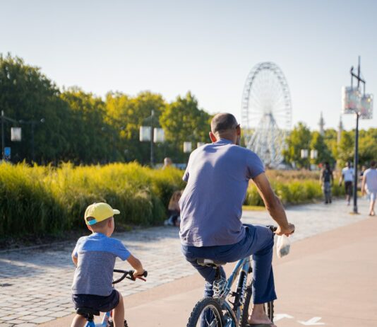 가족 건강을 위한 운동 프로그램 man in blue t-shirt riding on black bicycle during daytime