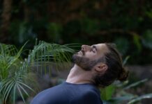 건강한 마음과 몸을 만드는 운동으로 스트레스 해소하기 a man sitting on a yoga mat in the middle of a forest