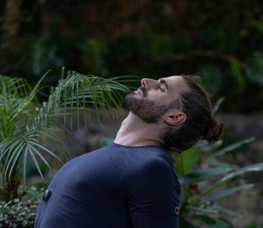 건강한 마음과 몸을 만드는 운동으로 스트레스 해소하기 a man sitting on a yoga mat in the middle of a forest