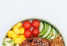 “맛있게, 건강하게! 요즘 뜨는 식단 트렌드와 실생활 실천법” A colorful poke bowl with fresh ingredients and chicken.