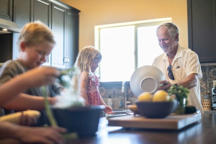 Photo by Land O'Lakes, Inc. Grandfather and grandchildren prepare food in kitchen